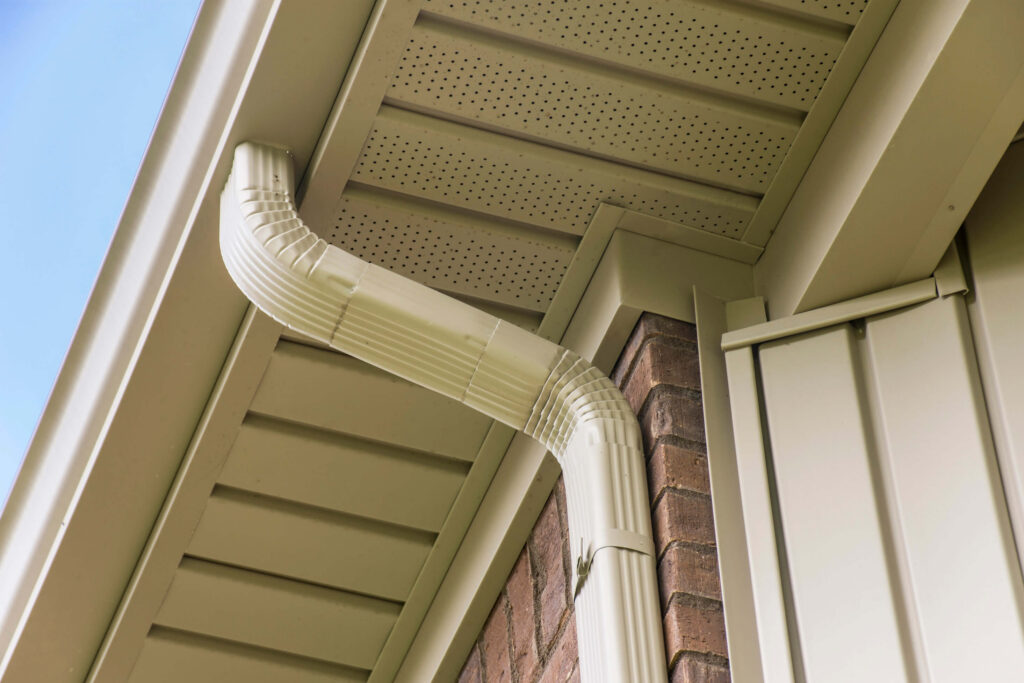 Gutter and downspout near the roof of a house.
